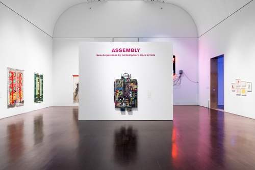 This image is Installation view of Assembly: New Acquisitions of Contemporary Black Artists, Blanton Museum of Art, The Unversity of Texas at Austin, December 11, 2021 - May 8, 2022. Pictured in the center of the image is an artwork by Noah Purifoy titled Restoration.